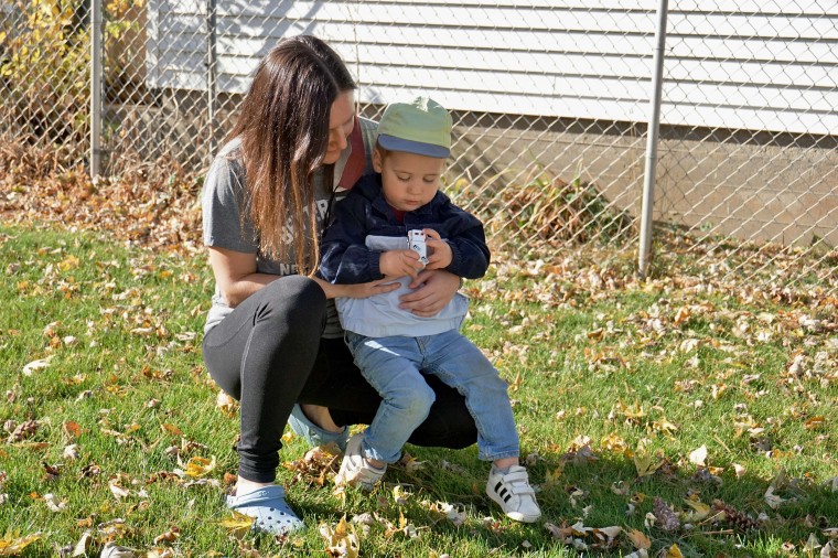 Emily holding her nephew in the backyard
