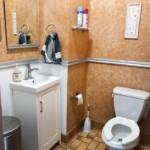 Half bathroom with small sink and mirror on the left and toilet on the rigjt