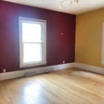 Deep red and yellow room with windows on the right and left
