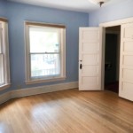Empty blue room with windows in the right and doors on left