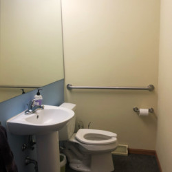 a bathroom with toilet and small sink