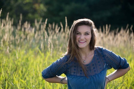 girl in a blue dress smiling in a field