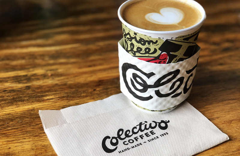 Colectivo coffee cup with coffee on-top of a Colectivo napkin